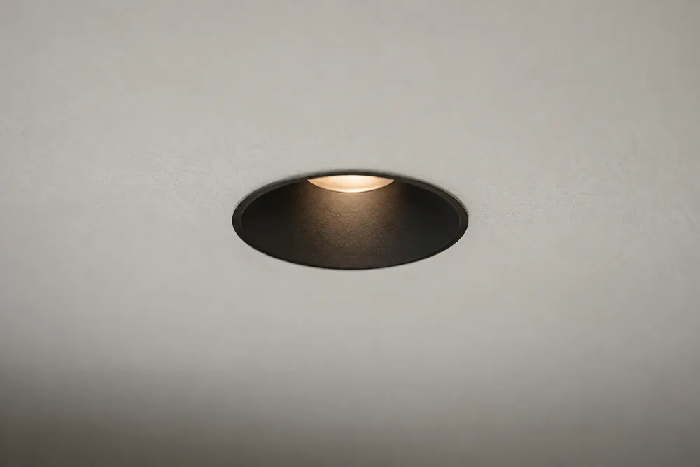 Illustrative close-up: a small recessed aperture with a deep matte black interior